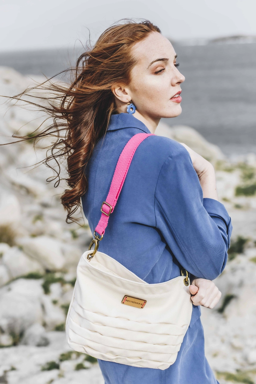 mujer de traje azul con bolso blanco ardora