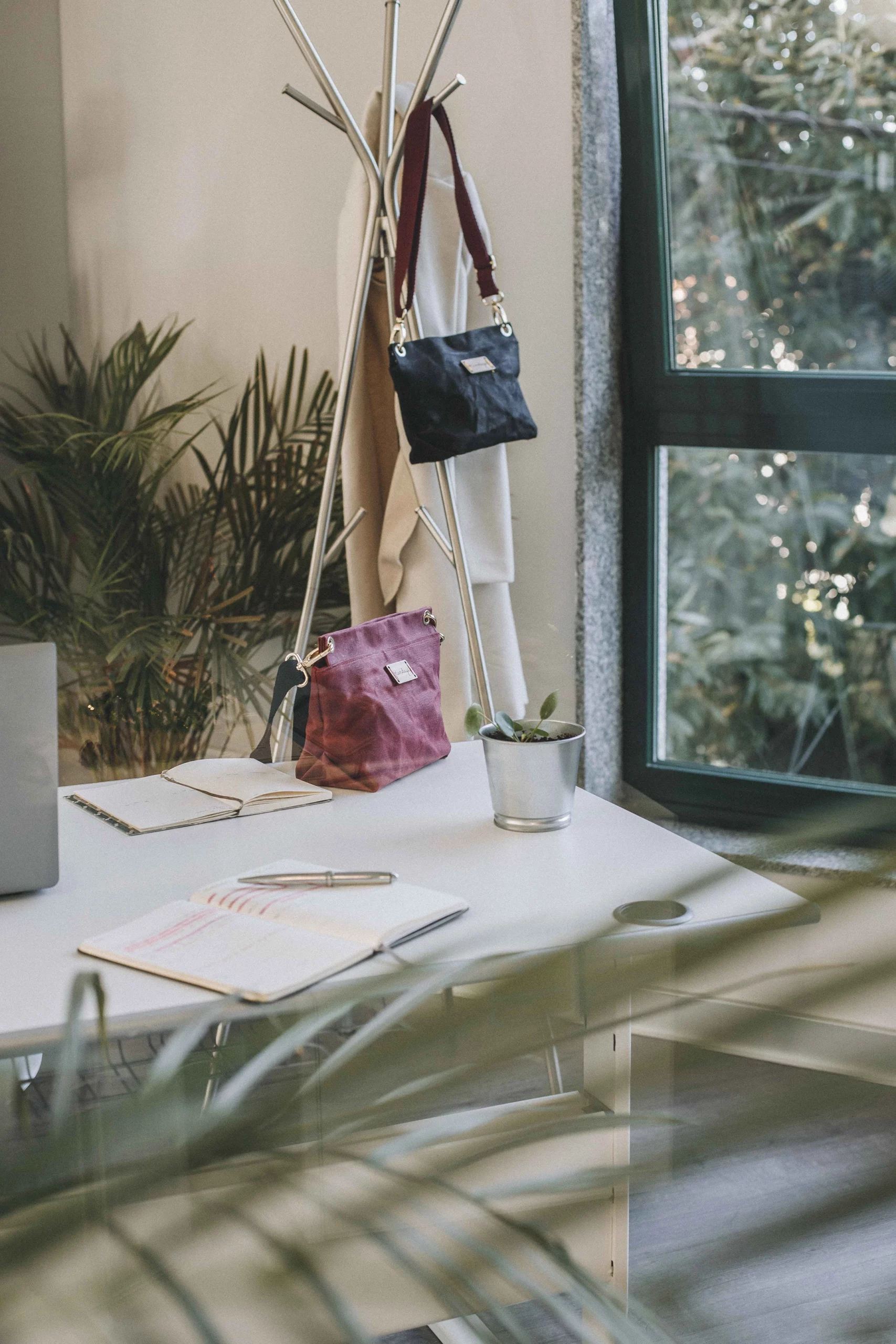 bolso bico granate y engro colgados de un perchero